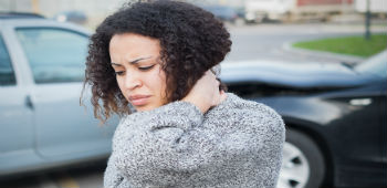 injured woman standing by car