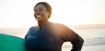 Smiling woman with surfboard