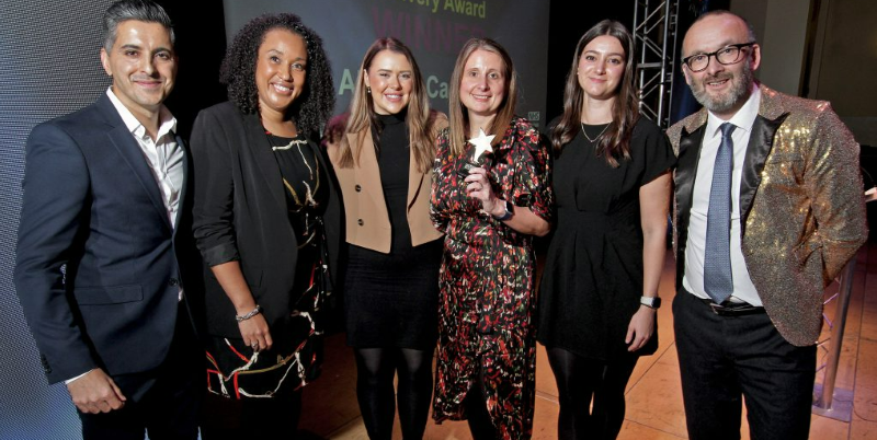 Group of smartly dressed people celebrating winning an award