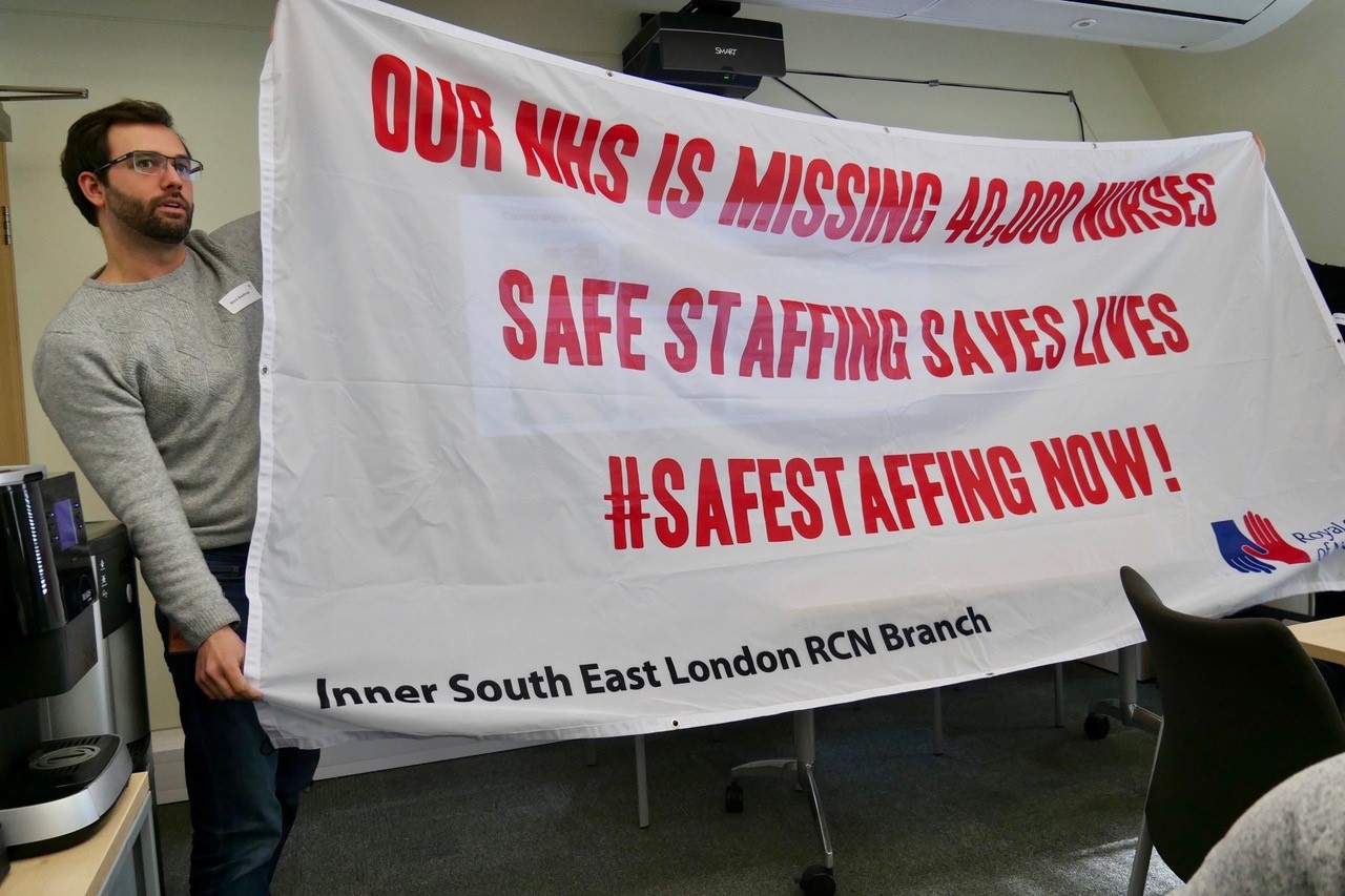 London members holding a safe staffing banner
