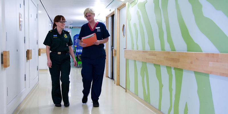 Nurses walk along a corridor in A&E