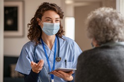 Image of masked nurse talking to patient