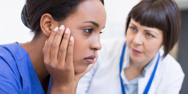Nurse looking sad while another looks on