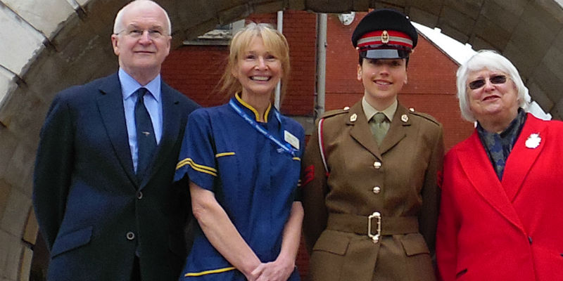 four people with big smiles standing outside a hospital