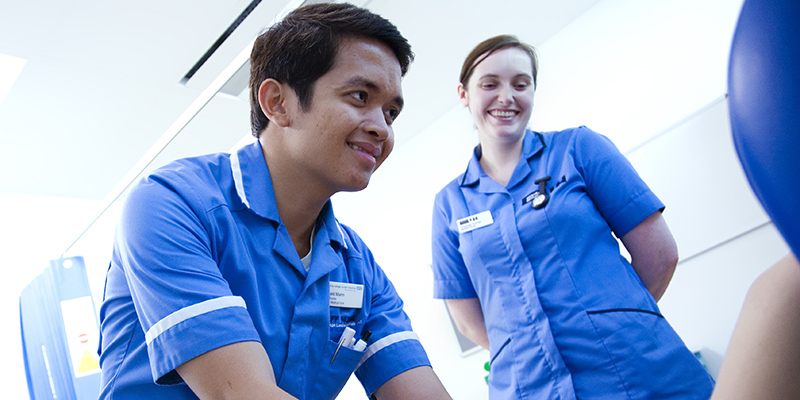Student nurse attending to a patient under supervision