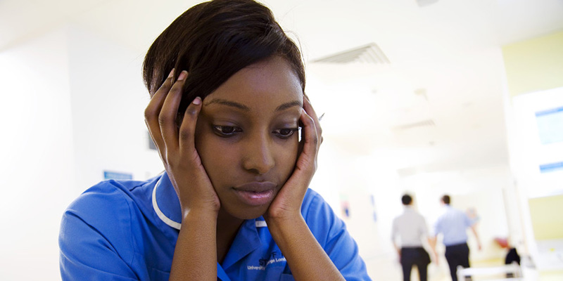 Nurse with head in her hands