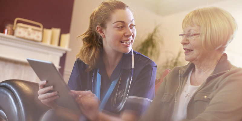 Community nurse advising patient at home