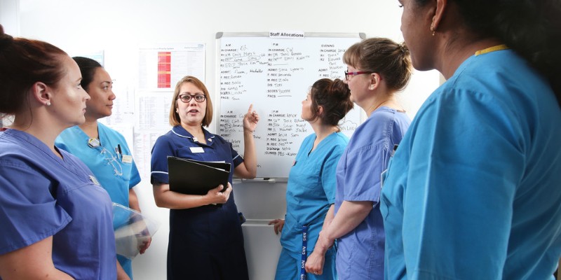 Nursing staff at Bradford Infirmary gather around a whiteboard to dicuss the day