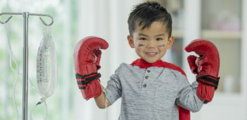 Little boy is hospital posing with boxing gloves