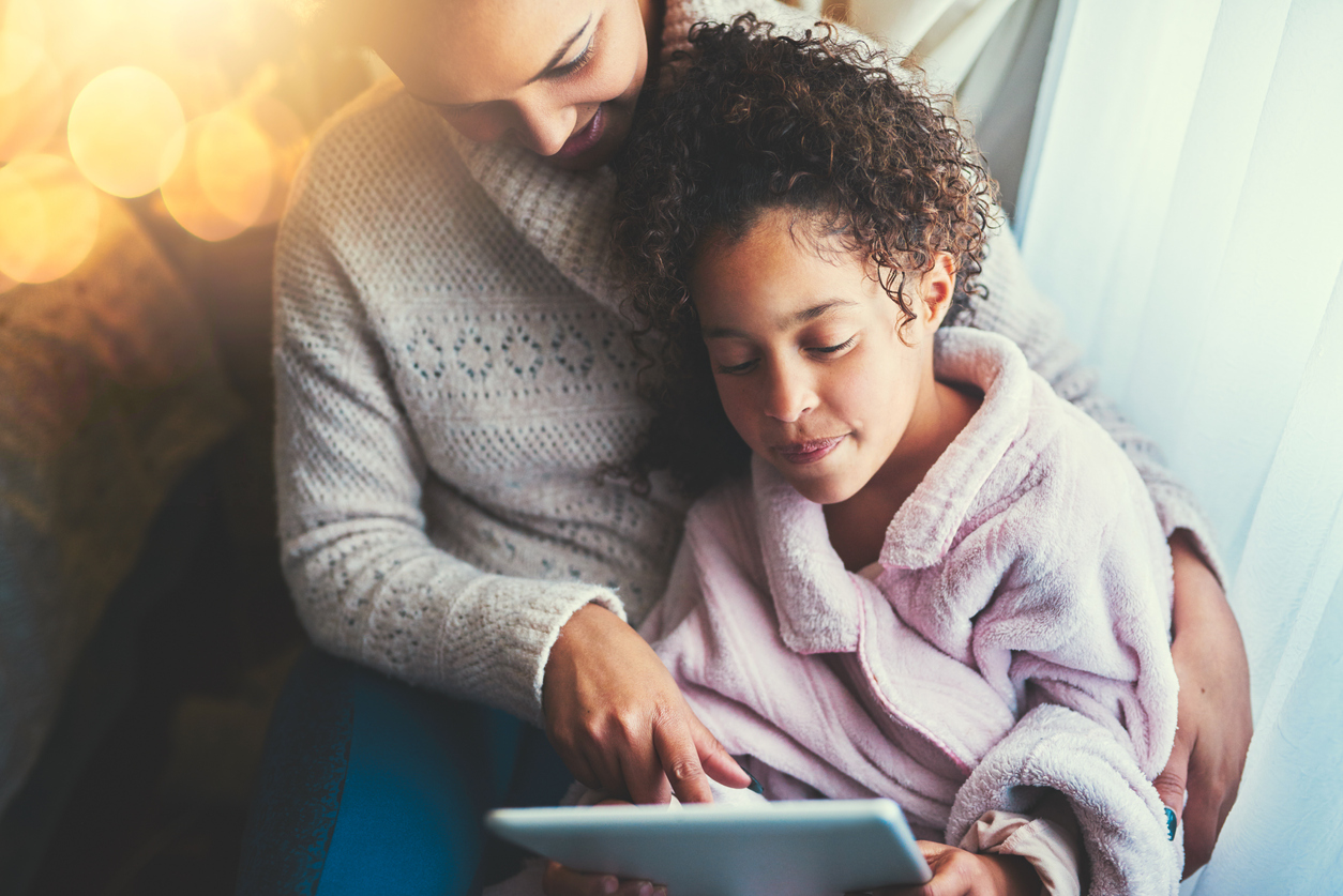 mom with daughter over the tablet