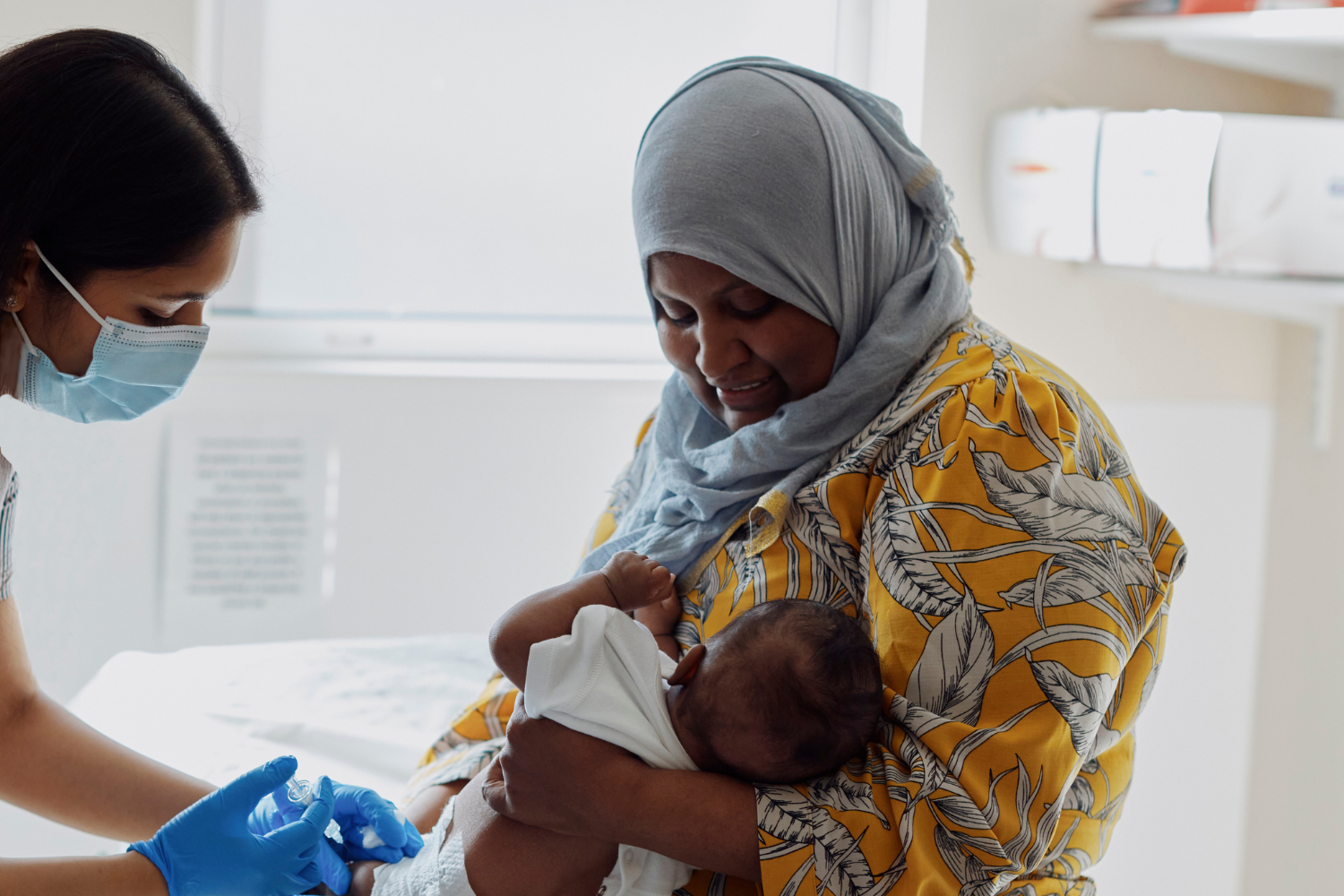 Mother with baby being seen by nurse