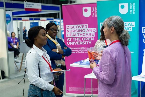 Two women speaking to an exhibitor