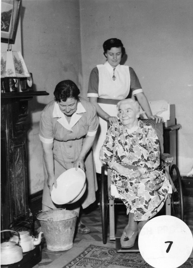 District nurses on a home visit to an older patient, c.1950. RCN Archive. 