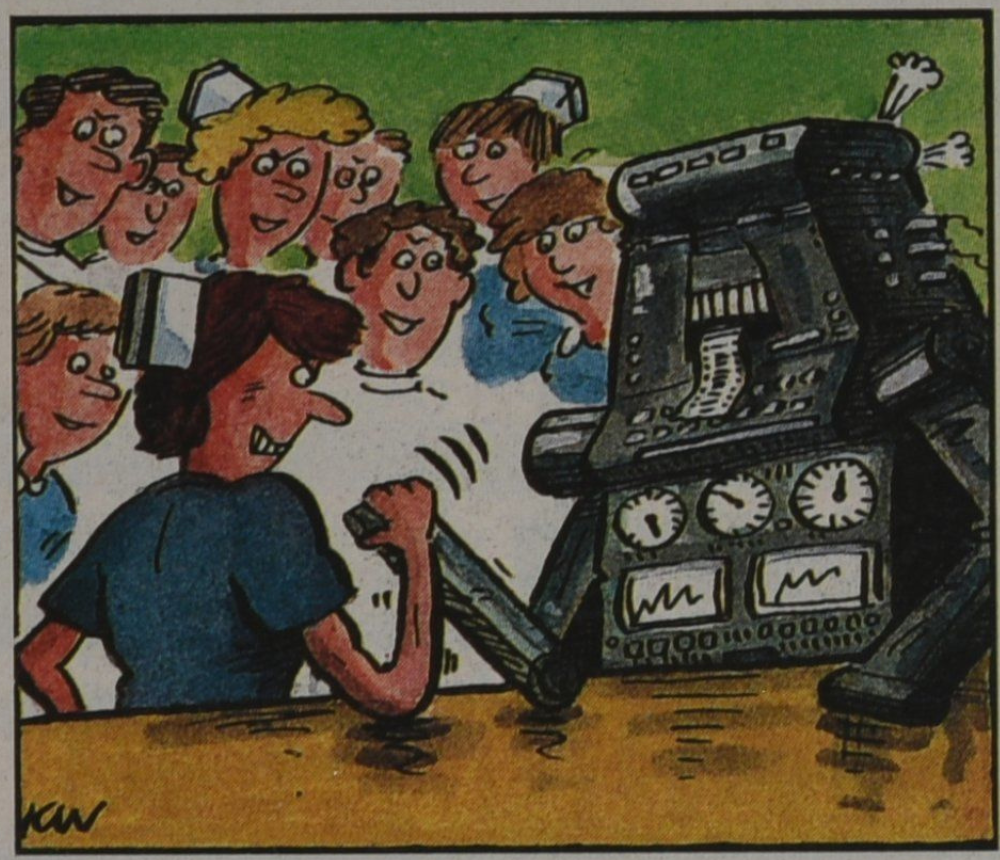 A colourful cartoon, signed 'KW', showing a woman nurse having an arm wrestle with a boxy, grey robot with dials and buttons - a group of 8 male and female nurses are watching in the background.