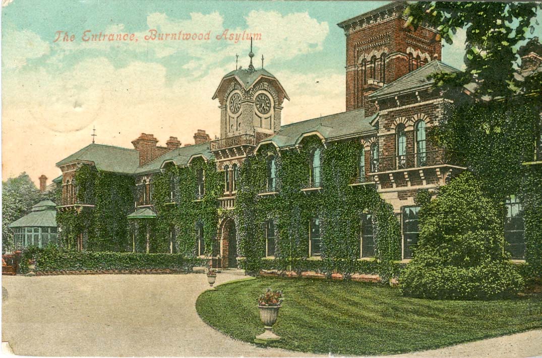 Colourised postcard of the exterior front of a two- storey building, with a central clock tower, covered in ivy.