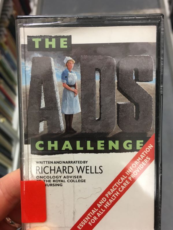The AIDS challenge narrated by Richard Wells RCN Oncology Adviser, 1987. The cover of a cassette tape featuring a nurse as the 'I' in Aids.