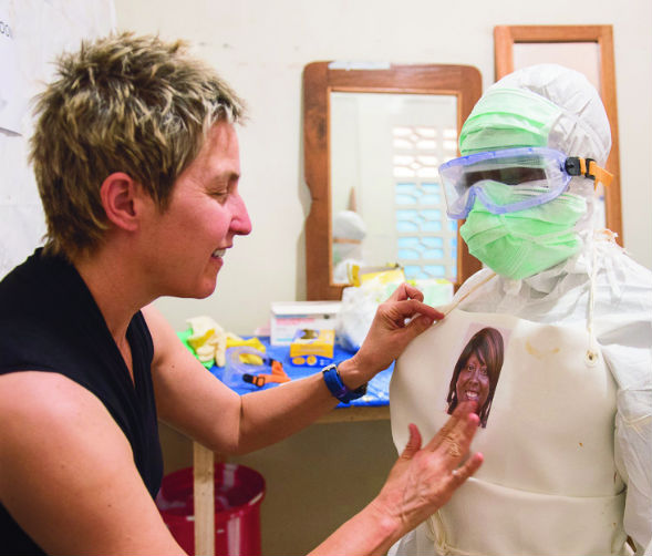 Artist Mary Beth Heffernan placing a nurse's picture on their PPE.