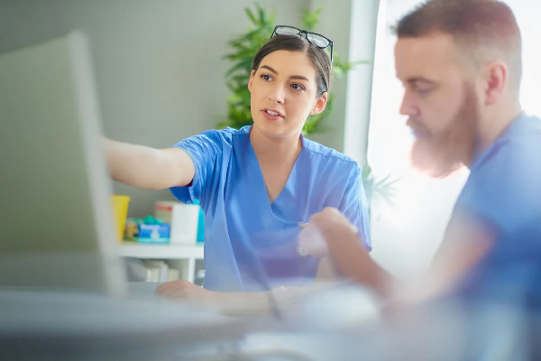 Two nurses looking at a computer