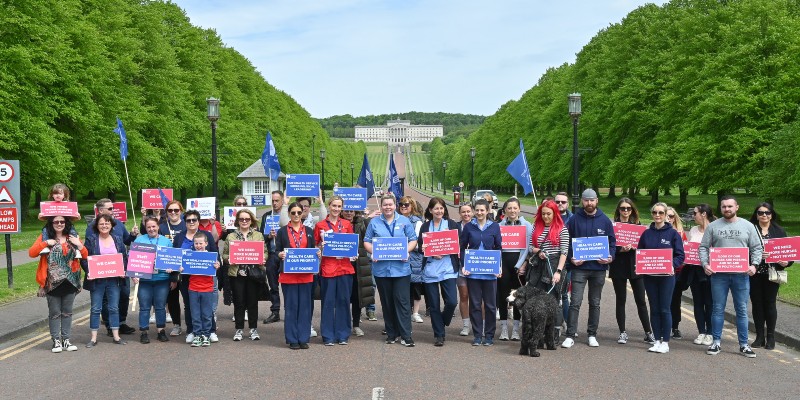 RCN members in Northern Ireland hold fair pay protest signs in front of Stormont