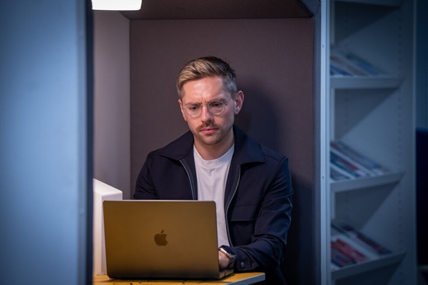 A student looking at his laptop and frowning