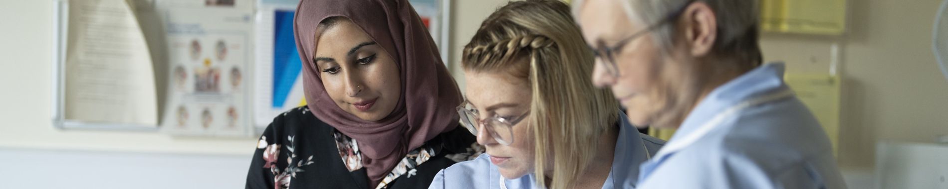 Consultant nurse talking to two nurses