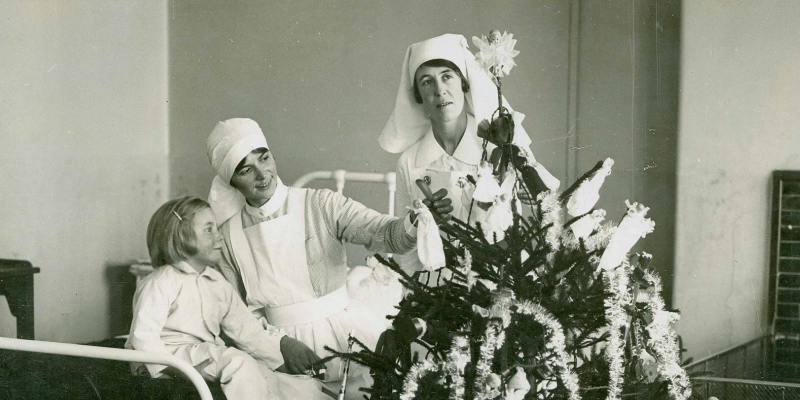 Two  nurses help a child decorate a tree at Mount Vernon Hospital, 1950