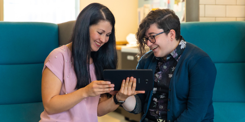 Two people using a tablet device
