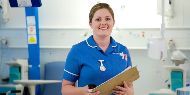 Nurse holding clipboard looking happy