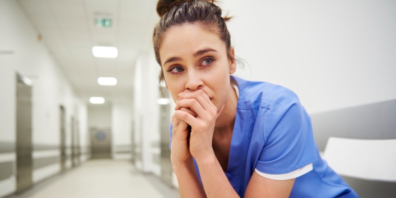 Member of nursing staff looking worried with tears in their eyes