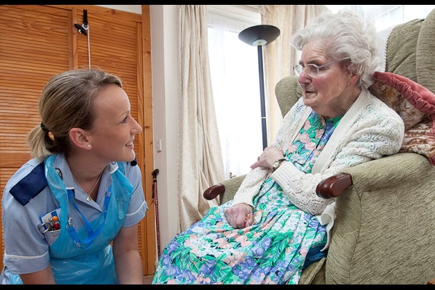 Community nurse tends to a wound on a patient's foot