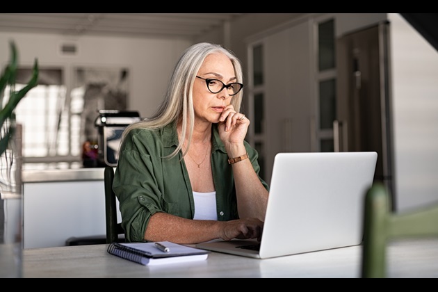 Woman sits in front of her laptop looking worried