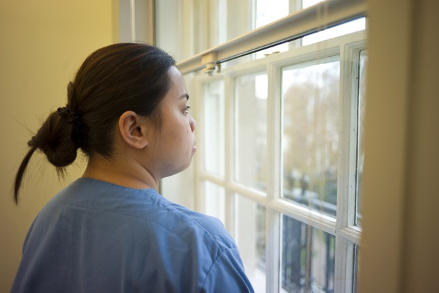 A nurse looking through a window
