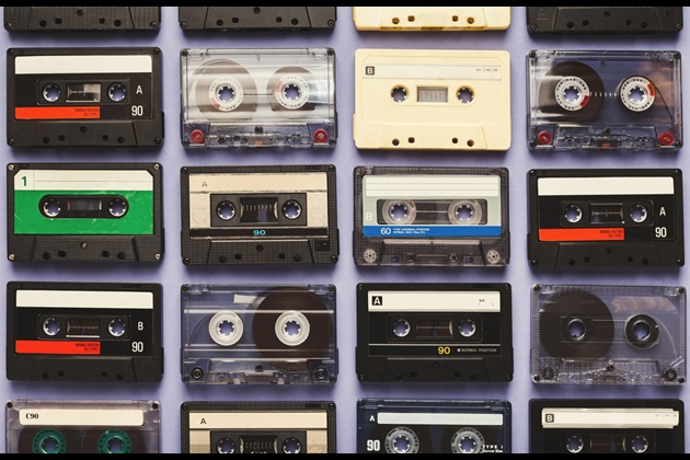 Cassette tapes lined up in grid against purple background Cassette tapes lined up in grid against purple background