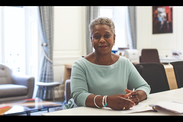 RCN Chief Executive & General Secretary Dame Donna Kinnair sat at a desk smiling