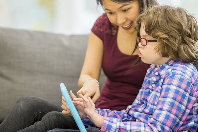 Woman and child with learning disability on tablet