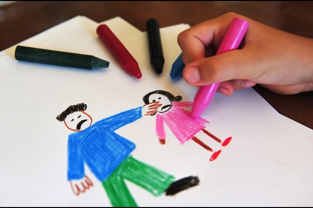 Child drawing a picture of an adult and child