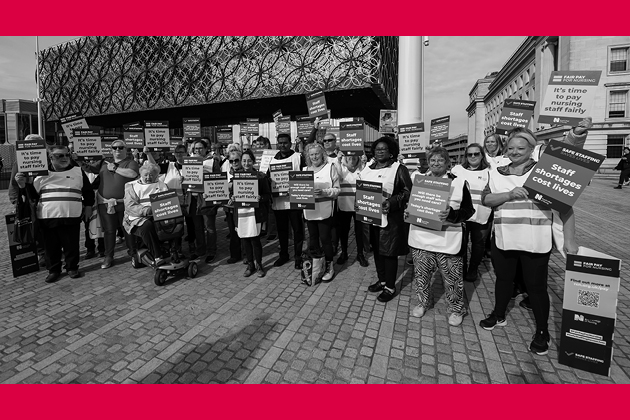 Black and white image with red border showing group of nurses holding fair pay placards