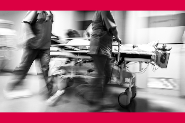 Black and white image with red border showing nursing staff rushing around in a hospital.