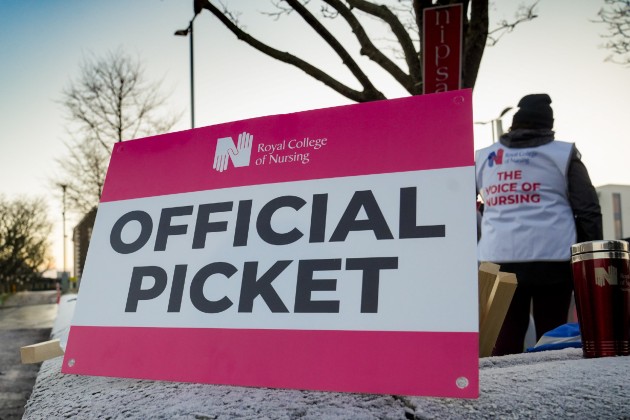 RCN official picket line sign with member in the background on frosty surface in NI