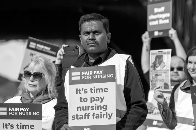 Nursing staff holding fair pay for nursing signs 