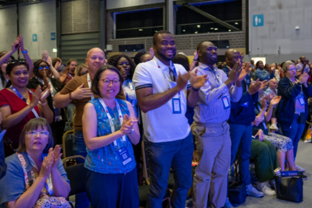 A crowd of people pictured watching Nicola Ranger's Congress 2025 keynote speech. Many of them are standing, clapping and smiling.