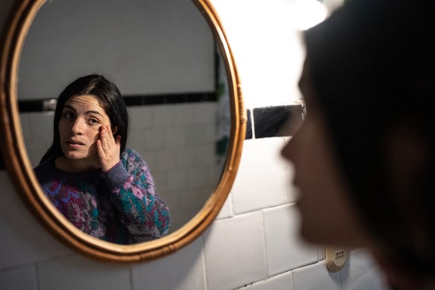 Woman looking in mirror showing concern at injury