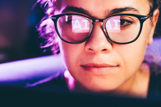 Person at computer with AI reflected in glasses