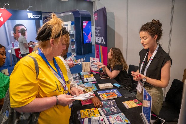 Woman wearing a yellow t-shirt browsing the RCN Congress Exhibition