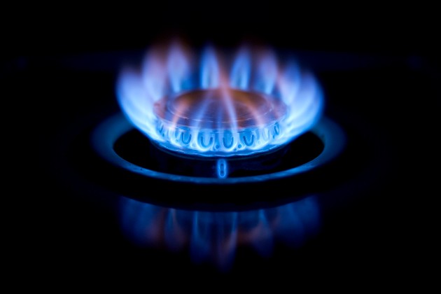 Stock image of gas hob burning with blue flame against black background