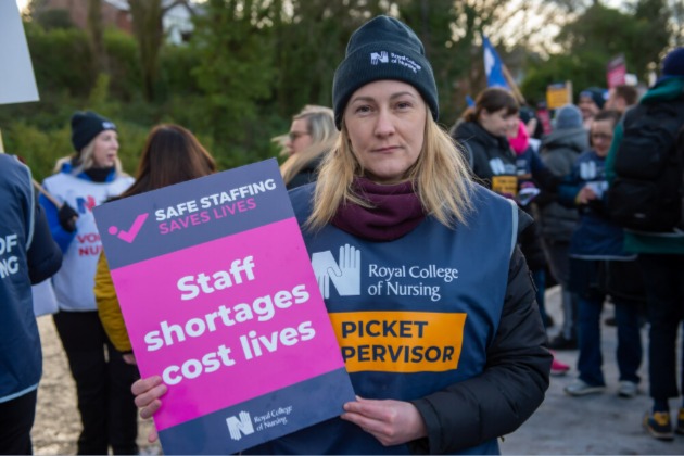RCN member on picket line with safe staffing sign at Royal Albert Edward Infirmary Wigan