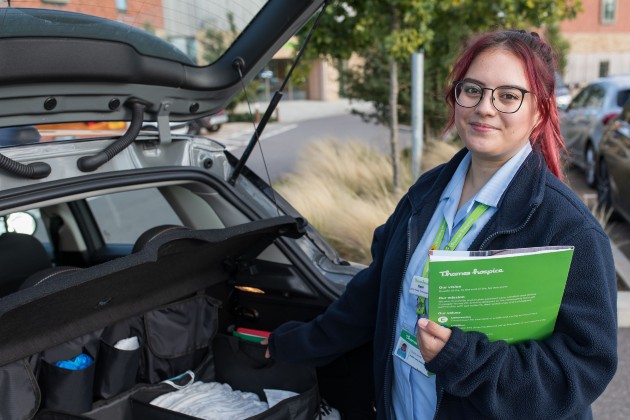 HCA Steph preparing to visit a patient standing by boot of car