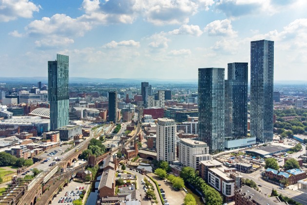 Aerial view of Deansgate area of Manchester city centre showing tower blocks, tram lines and more