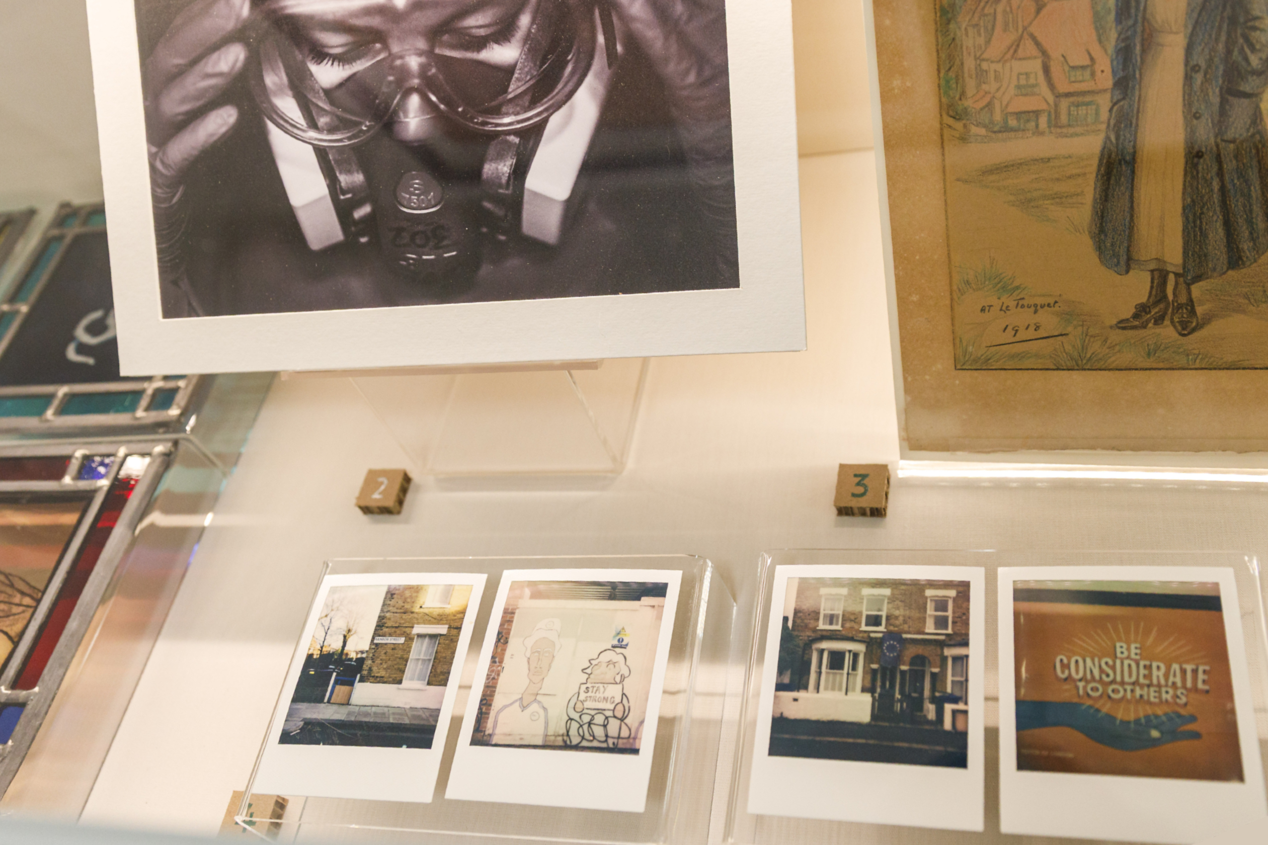 Photos are seen in a display case as part of the Art of Nursing exhibition at RCN HQ in London. A series of four London-inspired Polaroids called Rainbow Street by Panagiotis Poimenidis is shown.