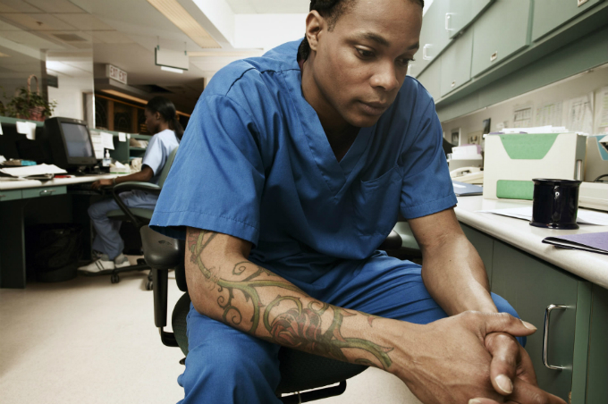 Male member of nursing staff looks worried